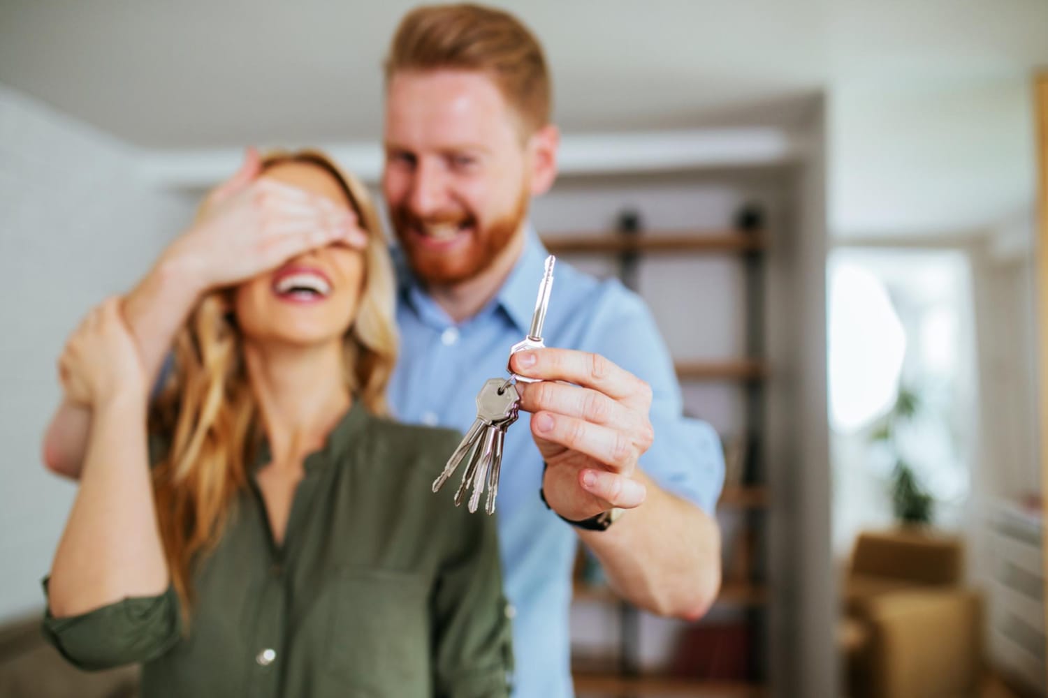 portrait-young-man-surprising-his-wife-with-keys-their-new-house